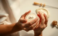 Hands applying moisturizing cream from a hand care company for healthy skin nourishment.